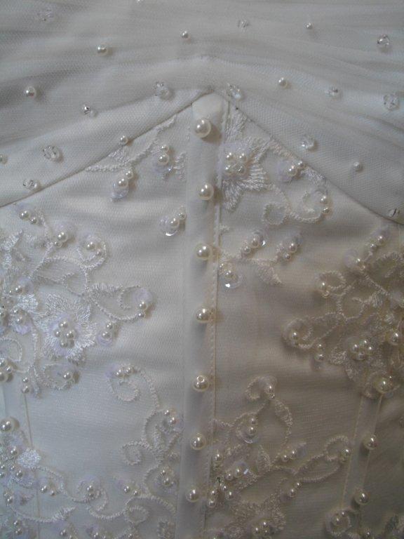 bodice is adorned with applique and faux pearls