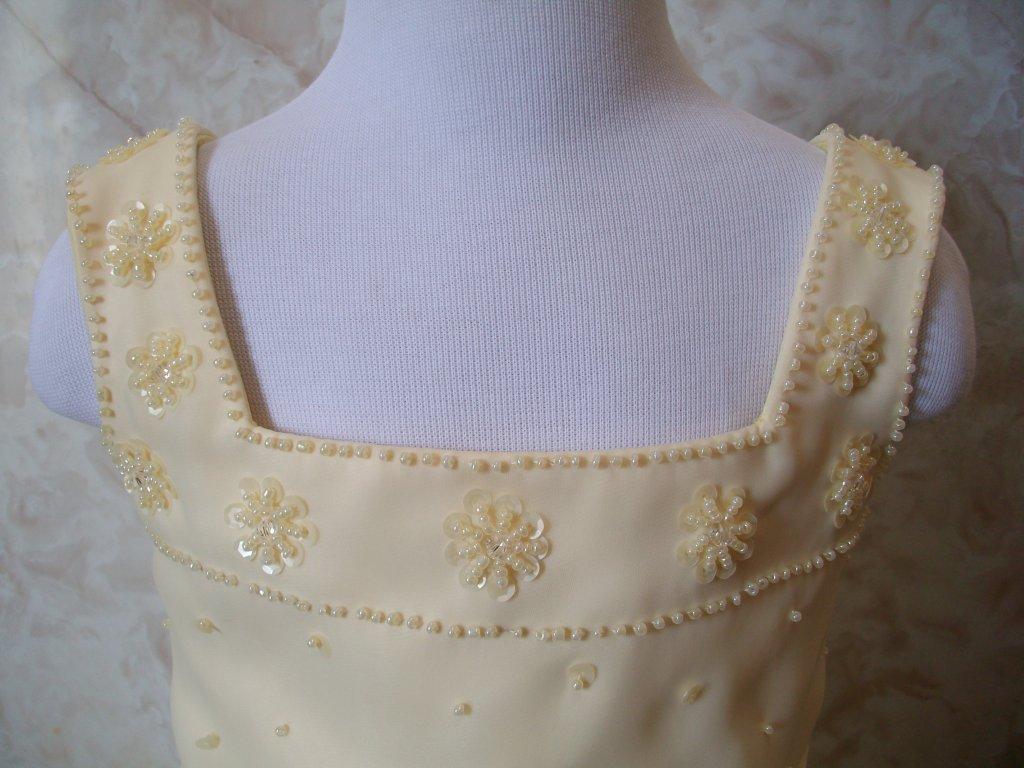 Flowers made out of beading and sequins adorn the square neckline of this buttercup yellow dress